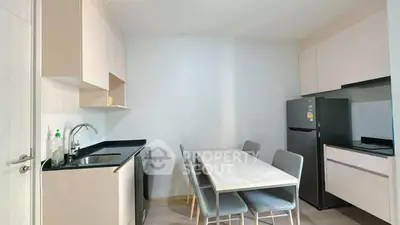 Modern kitchen with dining table, washing machine, and sleek cabinetry