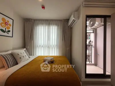 Cozy bedroom with modern decor and balcony access in a stylish apartment.