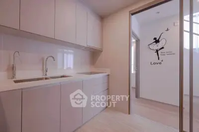 Modern kitchen with sleek cabinetry and elegant design, featuring a unique wall decal for added charm.