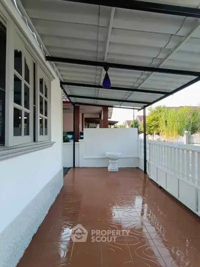 Charming covered patio with tiled flooring and decorative fountain, perfect for outdoor relaxation.