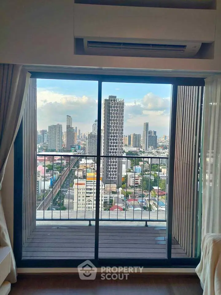 Stunning city view from a high-rise apartment balcony with floor-to-ceiling windows.