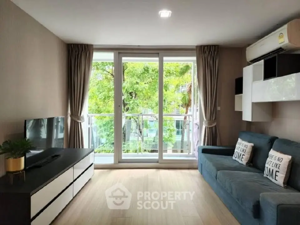Modern living room with large windows and stylish decor, featuring a cozy sofa and entertainment unit.
