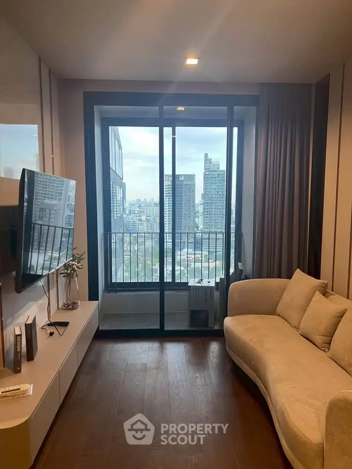 Modern living room with city view, featuring sleek furniture and floor-to-ceiling windows.