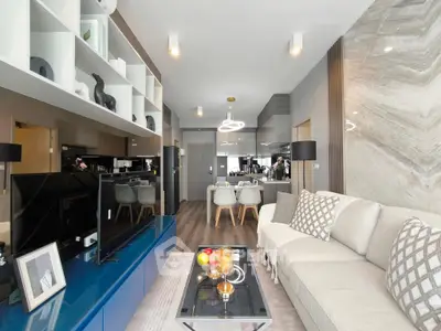 Modern living room with stylish decor and open layout, featuring a cozy sofa and elegant shelving.