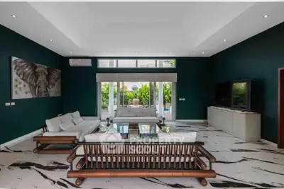 Luxurious living room with elegant decor and spacious seating area, featuring modern furniture and large windows.