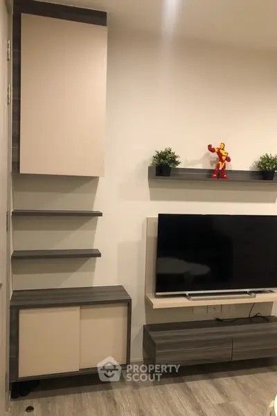 Modern living room with sleek TV unit and decorative shelves, perfect for stylish urban living.