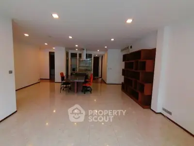 Spacious open-plan living room with modern kitchen and built-in shelving, ideal for contemporary living.