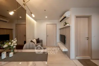 Modern living room with stylish decor and air conditioning, featuring a cozy sofa and wall-mounted TV.