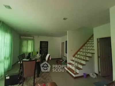 Spacious living room with staircase and natural light, ideal for modern family living.