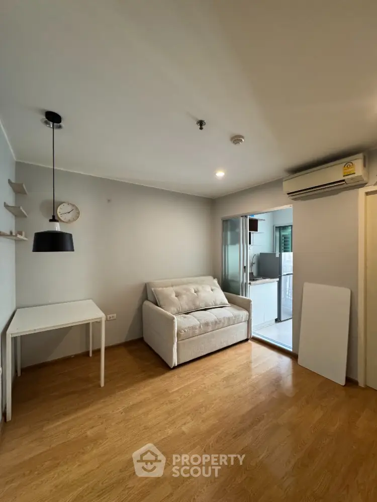 Cozy living room with modern sofa and wooden flooring in a compact apartment