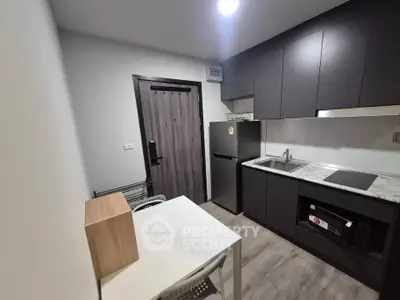 Modern kitchen with sleek black cabinets and compact dining area