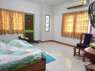 Spacious bedroom with natural light, air conditioning, and cozy decor.