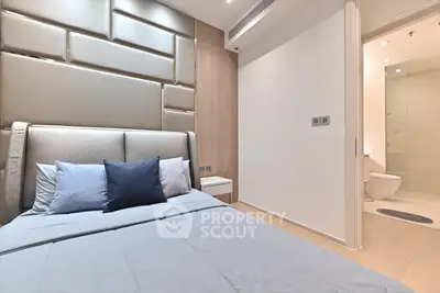 Modern bedroom with sleek design and ensuite bathroom in luxury apartment