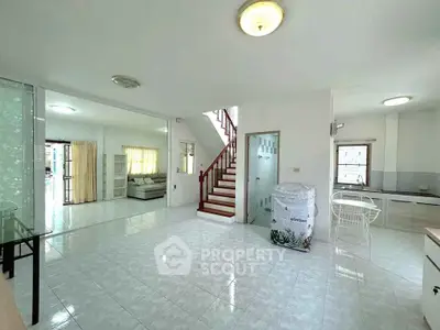 Spacious open-plan living area with modern staircase and natural light