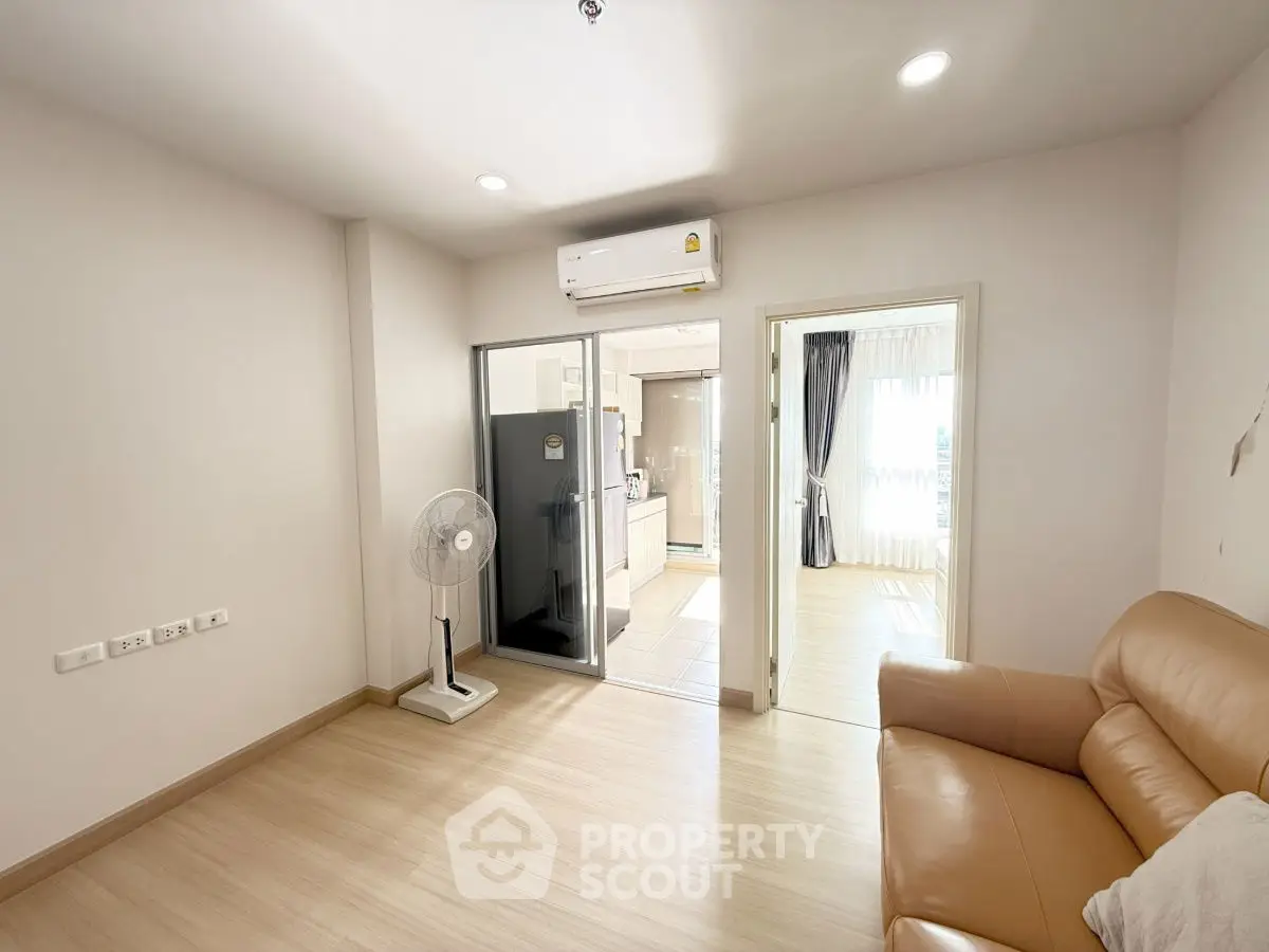 Modern apartment interior with open layout, featuring a cozy living room and sleek kitchen area.