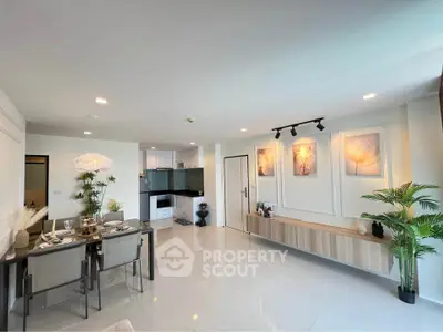 Modern open-plan living room with dining area and stylish kitchen in a bright apartment.