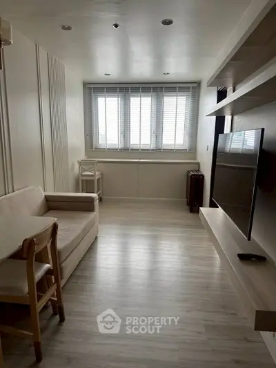 Modern living room with sleek design, featuring a wall-mounted TV and cozy seating area, perfect for relaxation.