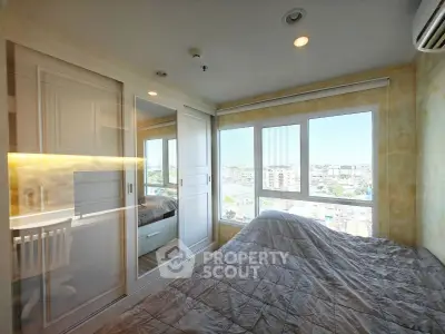 Bright bedroom with large windows offering stunning city views and ample natural light.