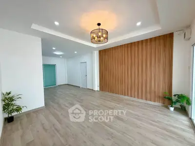 Spacious modern living room with wooden accent wall and elegant lighting