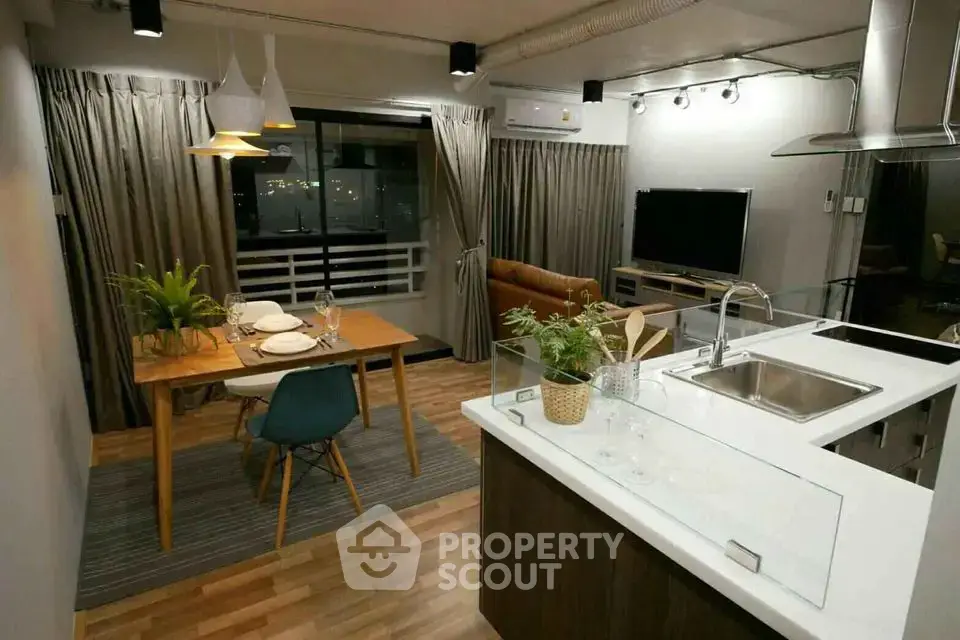 Modern open-layout living room and kitchen with stylish decor and dining area.