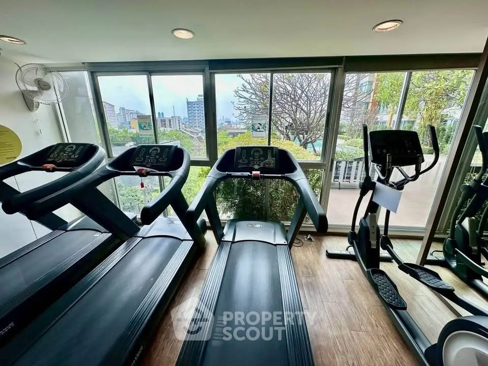 Modern gym with treadmills and large windows offering a scenic view, perfect for fitness enthusiasts.