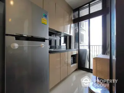 Modern kitchen with sleek cabinets and stainless steel fridge in a bright apartment.