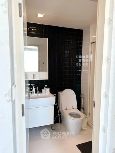 Modern bathroom with sleek black tiles and white fixtures