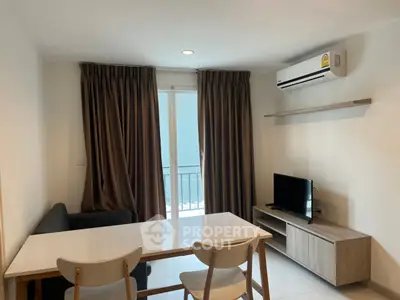 Modern living room with sleek furniture and balcony access in a stylish apartment.