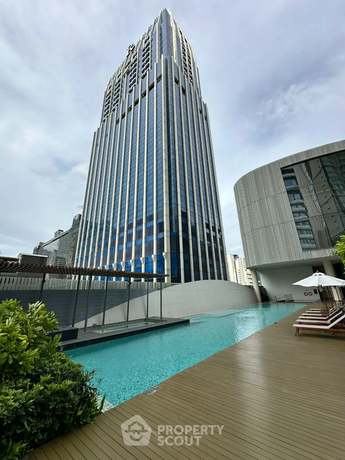 Luxurious high-rise building with poolside deck and modern architecture.