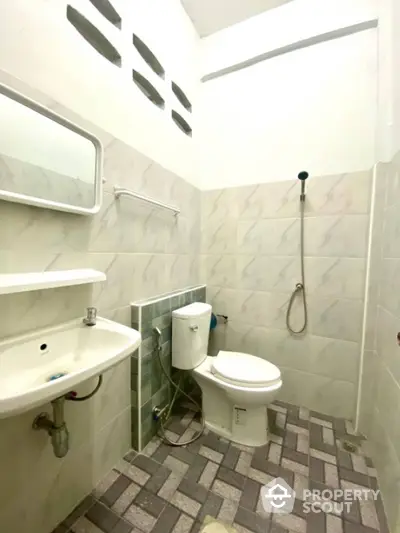 Compact bathroom with modern fixtures and tiled walls, featuring a shower and toilet.