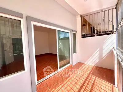 Spacious balcony with sliding glass doors and tiled flooring, perfect for relaxation.