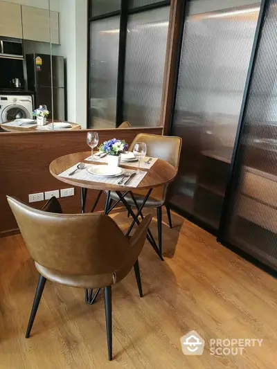 Modern dining area with stylish table and chairs, adjacent to a sleek kitchen space.