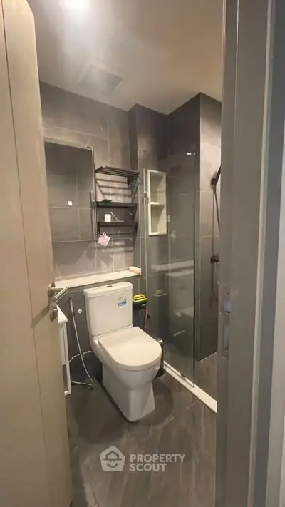 Modern bathroom with sleek design, featuring a glass shower and contemporary fixtures.