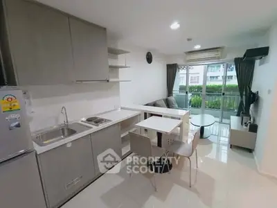 Modern open-layout kitchen and living room with balcony view in a stylish apartment.