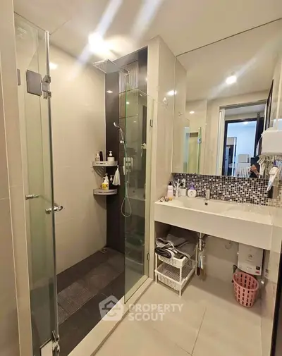 Modern bathroom with glass shower and stylish vanity in a contemporary home.