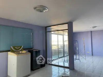Spacious interior with washing machine and glass doors leading to balcony