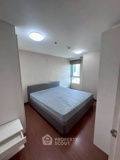 Spacious bedroom with large bed and natural light in modern apartment