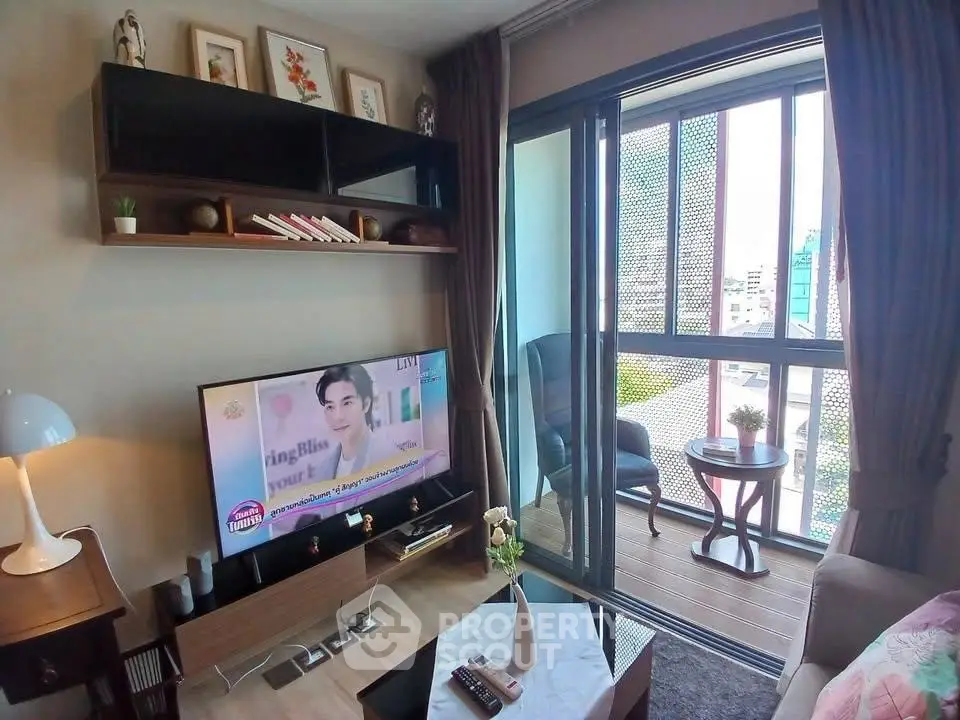 Cozy living room with balcony view, modern decor, and natural light in urban apartment.