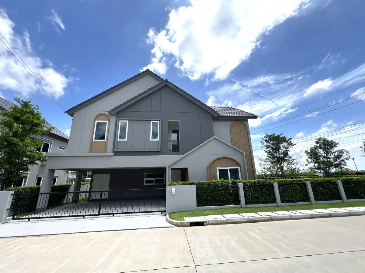 Modern two-story house with sleek design and lush greenery under a clear blue sky.