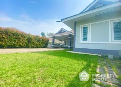 Charming single-story home with lush green lawn and spacious driveway in a serene neighborhood.