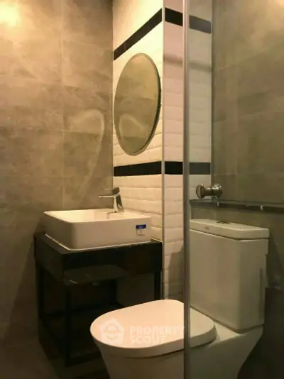 Modern bathroom with sleek design featuring a round mirror and contemporary fixtures.