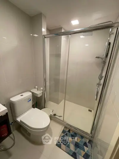 Modern bathroom with glass shower enclosure and sleek fixtures