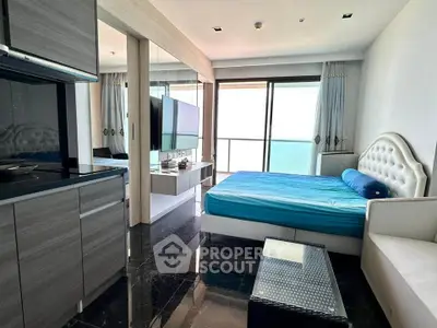 Modern studio apartment with ocean view, featuring sleek kitchen and cozy sleeping area.