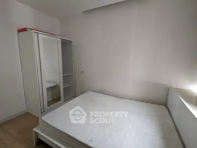 Minimalist bedroom with white wardrobe and bed frame, perfect for modern living.