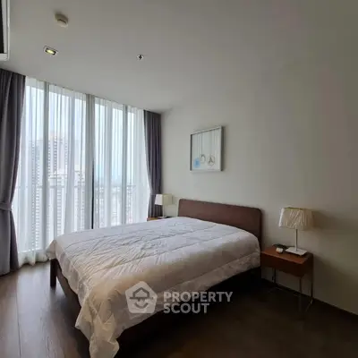 Modern bedroom with large windows and elegant decor in a high-rise apartment.