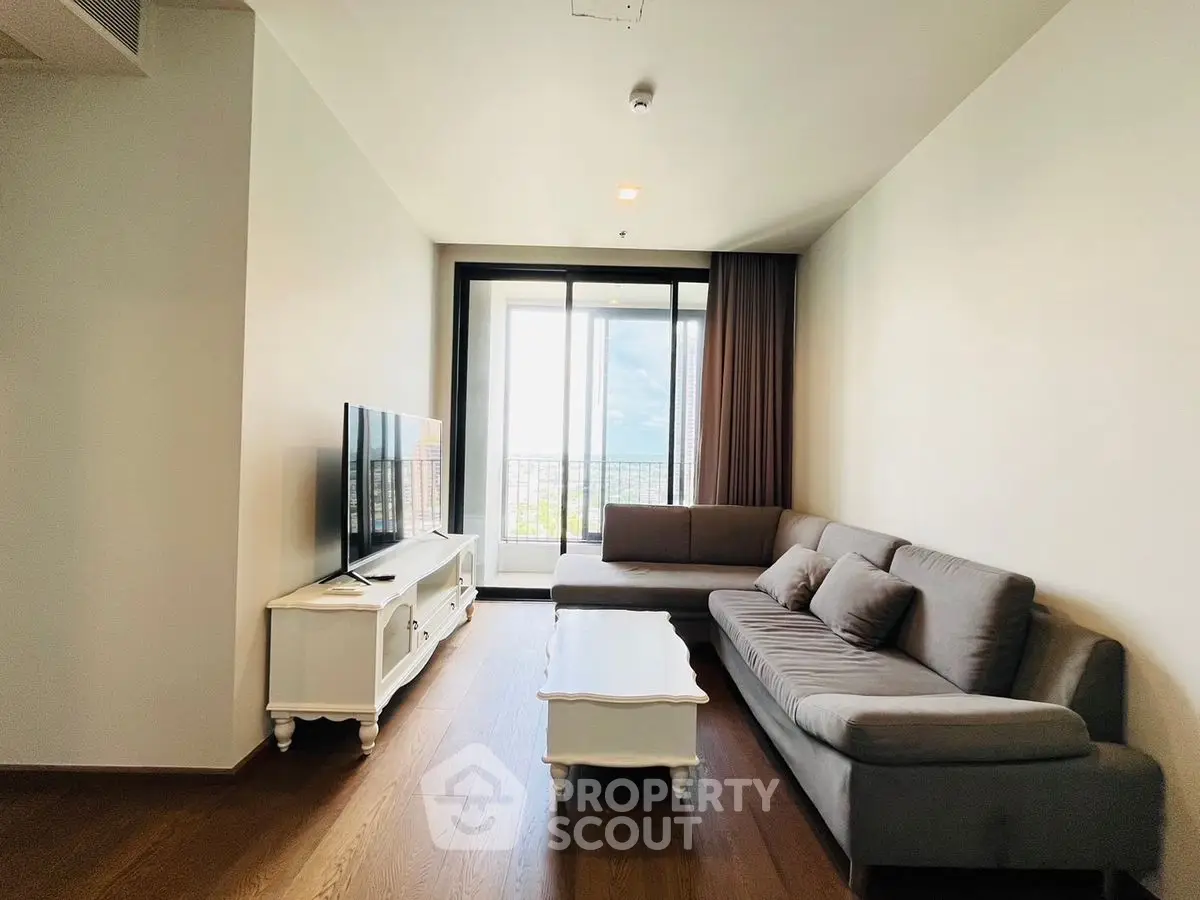 Modern living room with large windows and stylish furniture, offering a bright and inviting atmosphere.