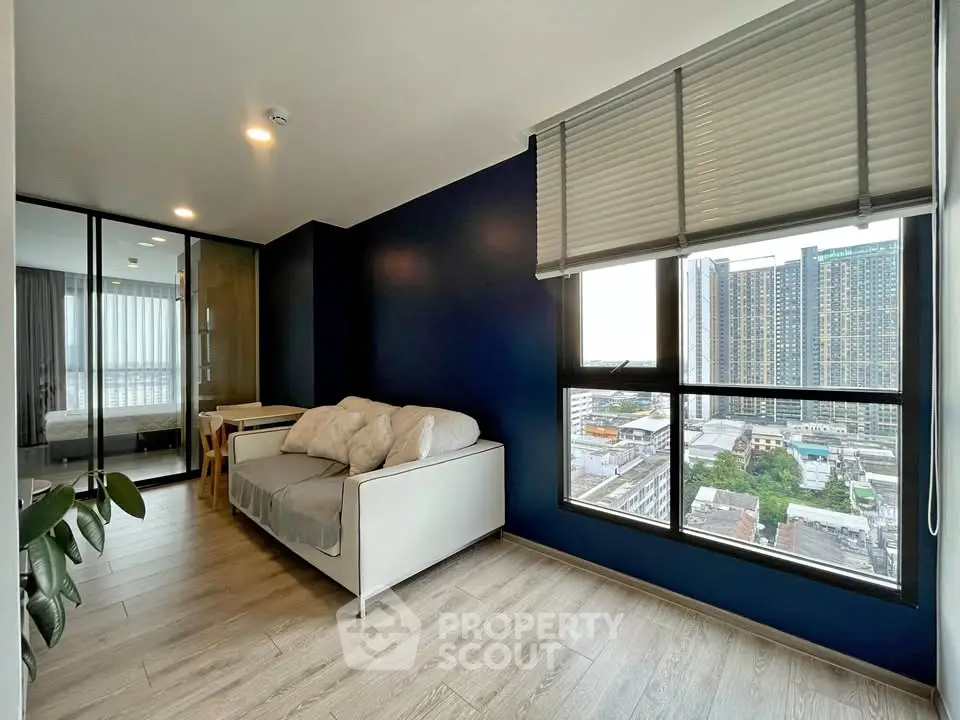 Modern living room with city view, featuring sleek design and large windows for natural light.