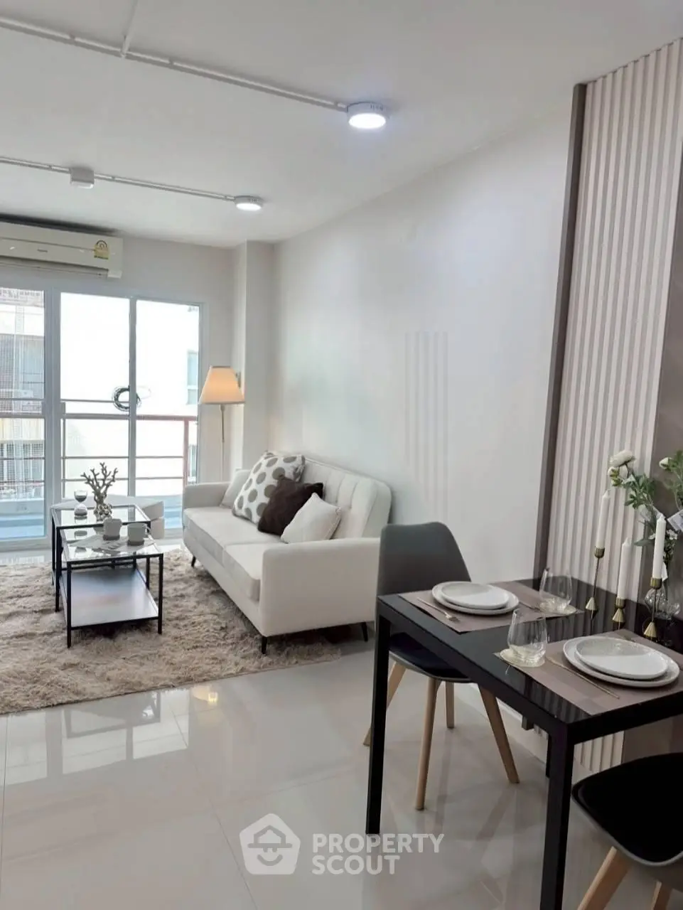 Modern living room with cozy sofa, dining area, and balcony access in stylish apartment.