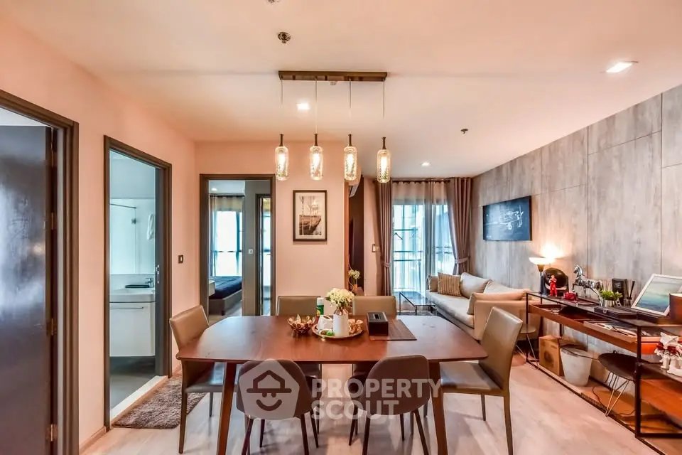 Spacious modern dining area with elegant lighting and cozy living room view.