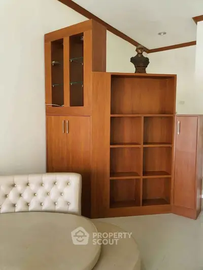 Elegant wooden shelving unit with glass cabinet in stylish living room corner